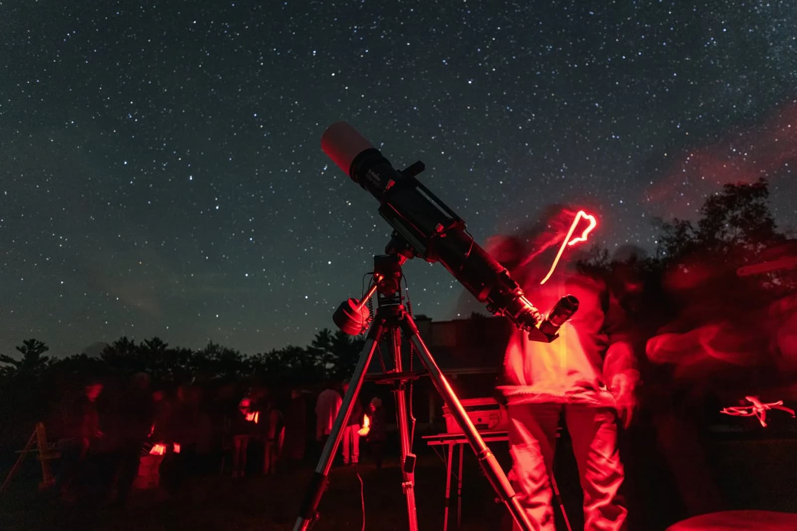 Observers gather around a telescope under a star-filled sky at Saint-Gaudens National Historical Park.